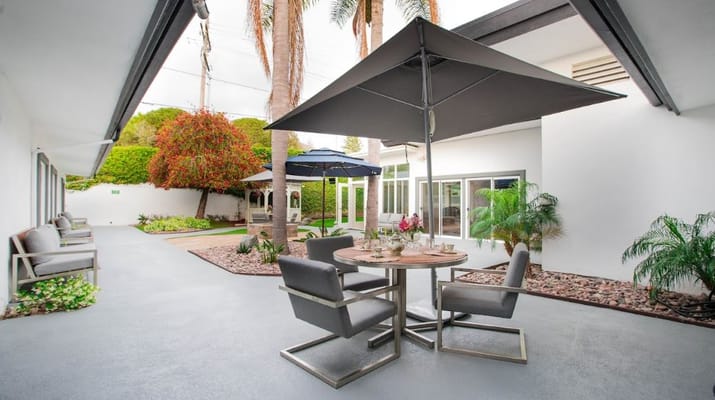 Outdoor seating area with plants and umbrellas