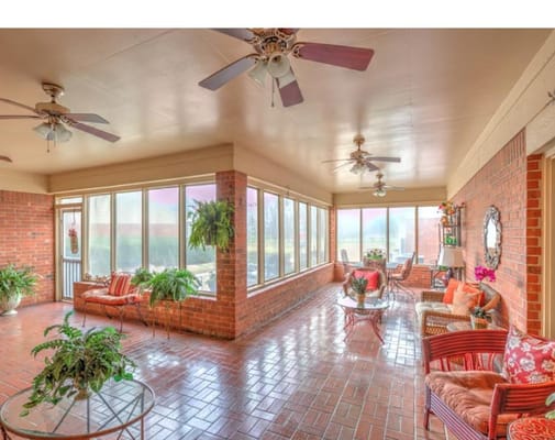 Well-lit sunroom with seating and plants