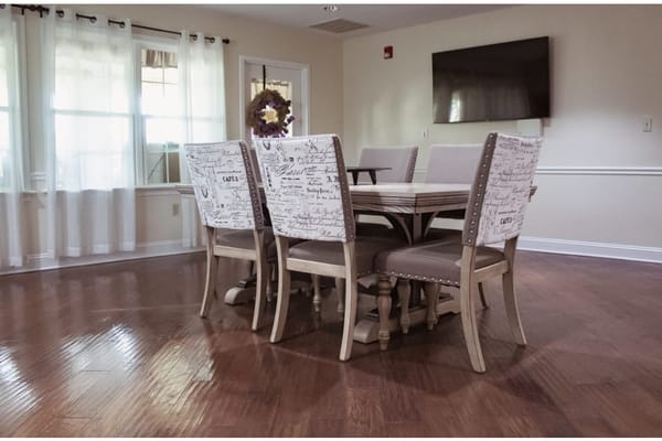 Brightly lit dining area with wooden table and chairs