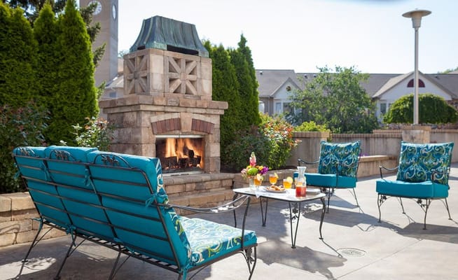 Cozy outdoor lounge with seating and a fireplace at StoryPoint Kalamazoo.