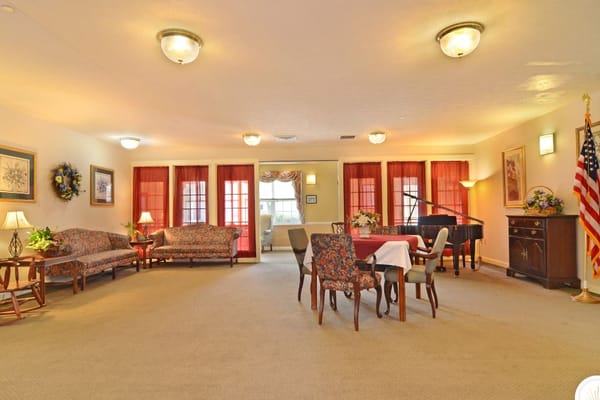 Bright common area with seating and a piano