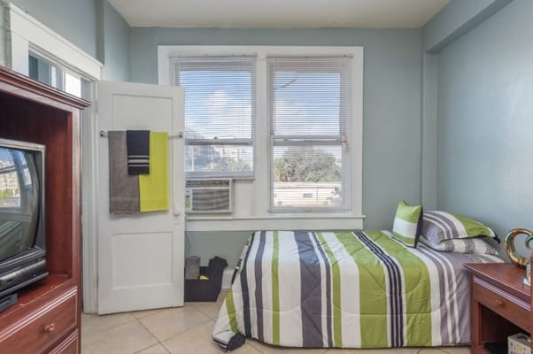 Bright private room with a bed and air conditioner