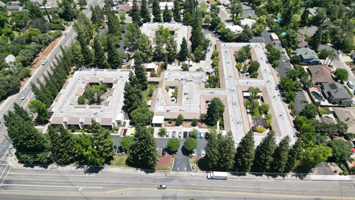 Aerial view of a senior living campus surrounded by trees