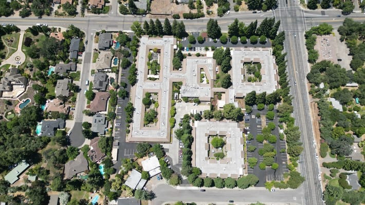 Aerial view of a senior living facility with green landscaping