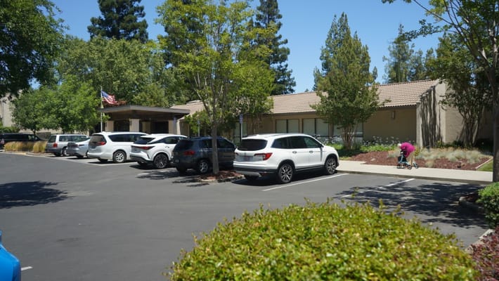 Exterior view of assisted living facility with parking and landscaping