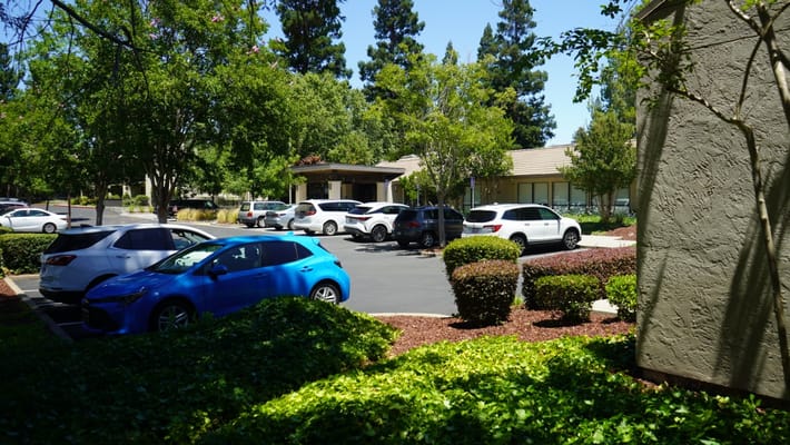 Parking area with trees and facility in the background