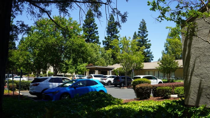 View of the facility with parking and trees