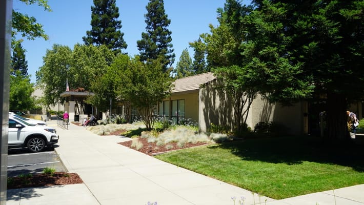 Exterior view of a senior living facility entrance and garden