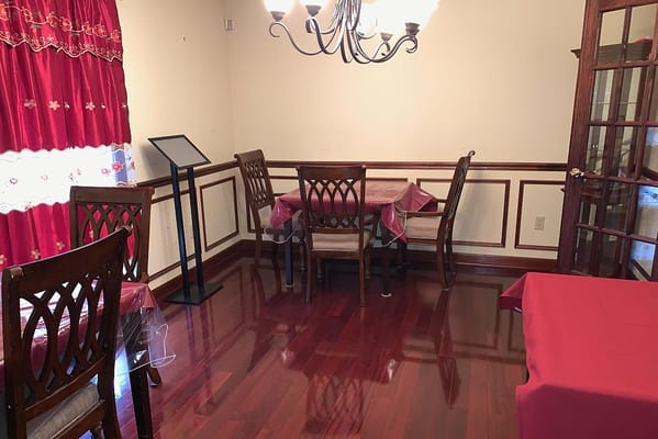 Dining room with wooden chairs and red tablecloths