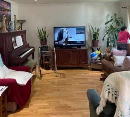 Residents in a cozy living room with furniture and plants
