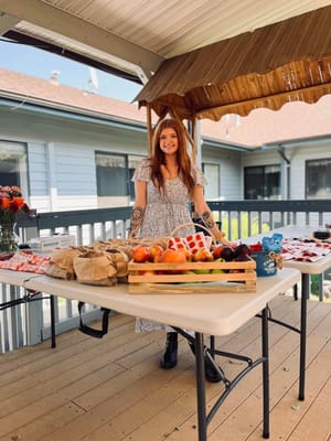 Staff member at an outdoor event with fresh fruits