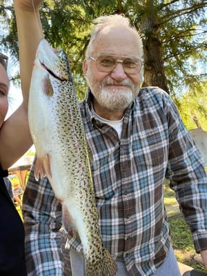 Resident proudly holding a large fish outdoors