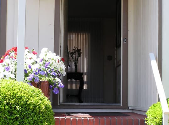 Entrance of a facility with flower pots and a welcoming door