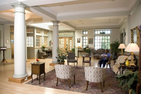Bright common area with seating and a resident reading