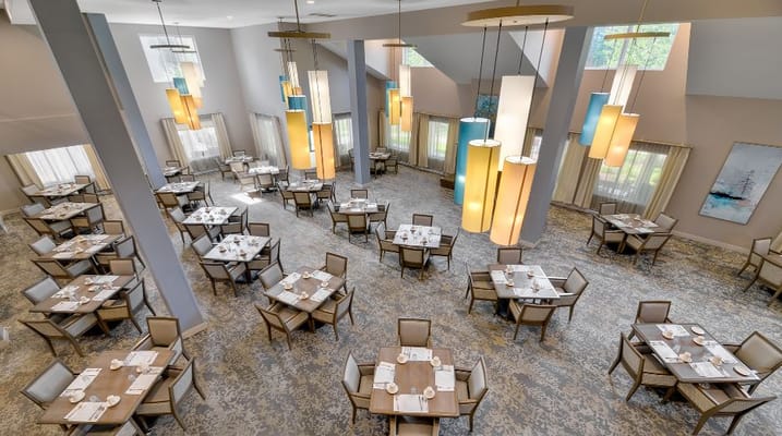 Spacious dining area with multiple tables and colorful lighting