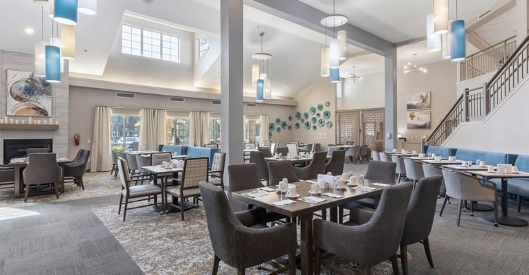 Bright and spacious dining room with tables set for meals.