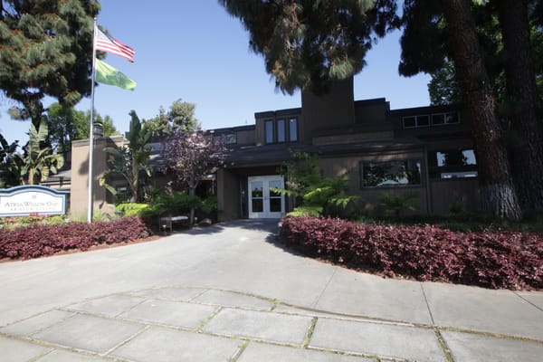 Front view of a senior living facility with gardens