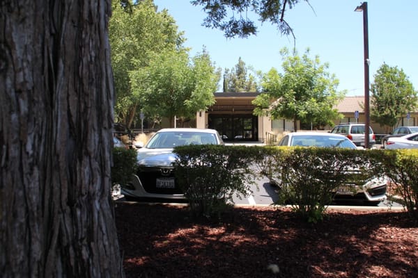 Entrance view of a senior living facility with parked cars