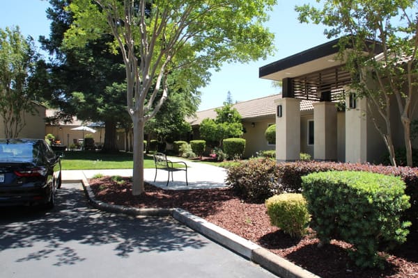 Exterior view of a senior living facility with landscaped gardens