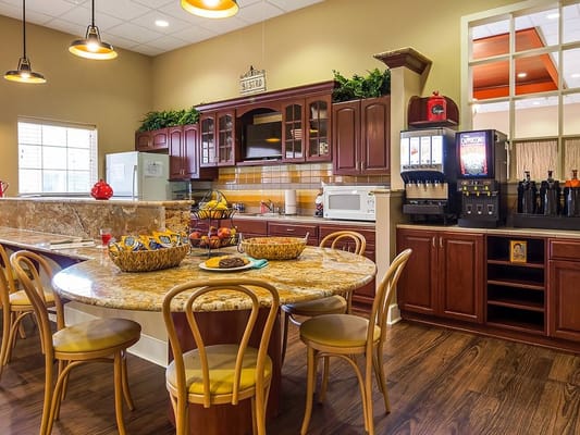 Warm and inviting kitchen bistro with a round granite table and modern appliances