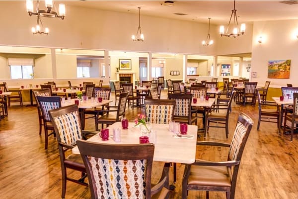 Brightly lit dining room with tables set for meals