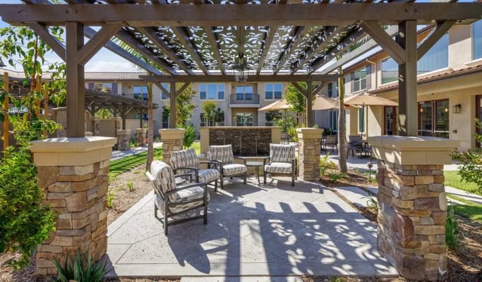 Outdoor seating area with decorative trellis and landscaping