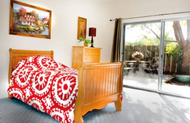 Cozy bedroom featuring a wooden bed and red patterned blanket
