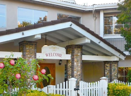 Entrance of Paradise Villa with 'Welcome' sign and floral garden