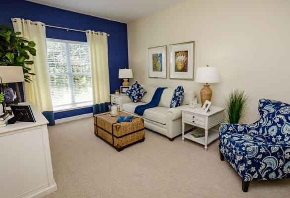 Bright living room featuring a cream-colored sofa and blue decor.