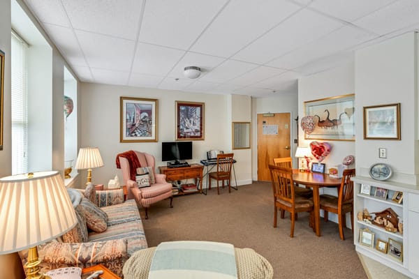 A cozy living room featuring a sofa, a dining table, and decor.