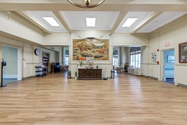 Spacious lobby with wooden flooring and a mural