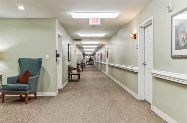 A well-lit hallway with seating arrangements and wall decor.