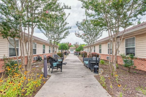 A peaceful courtyard at Spring Oak Lexington featuring seating and flower beds.