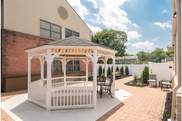 White gazebo surrounded by landscaped outdoor area