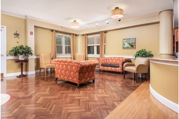 Comfortable seating area with chairs and a couch in a warm-colored lobby.