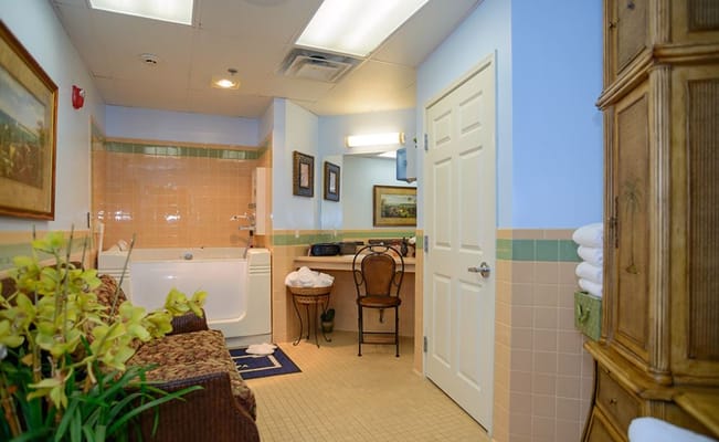 Bathroom with a tub, chair, and decorative accents.