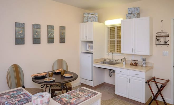 A cozy kitchen area with a round table and decorative wall art.