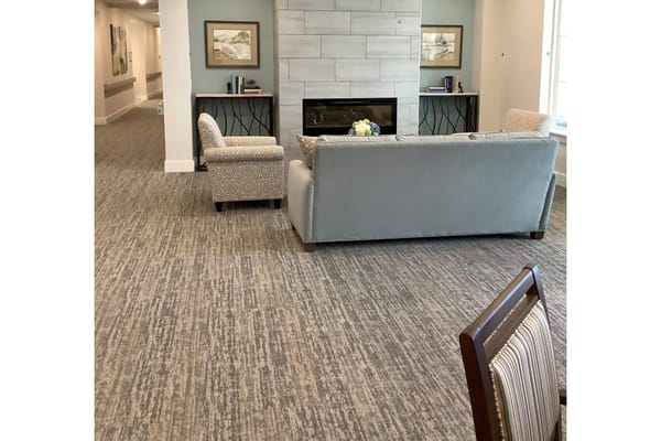 Cozy lounge area with a couch and armchairs, featuring a fireplace