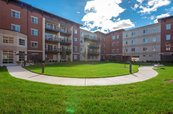 Lush green courtyard with pathways and balconies at The Carrington at Lincolnwood