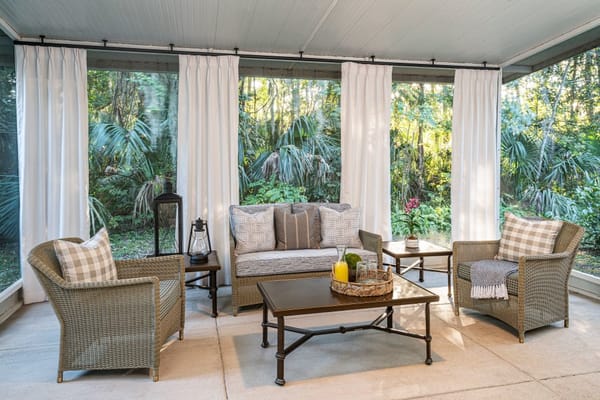 Comfortable sunroom with seating and lush greenery outside