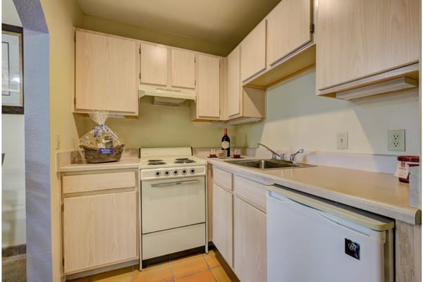 Bright and tidy kitchen with wooden cabinets and appliances