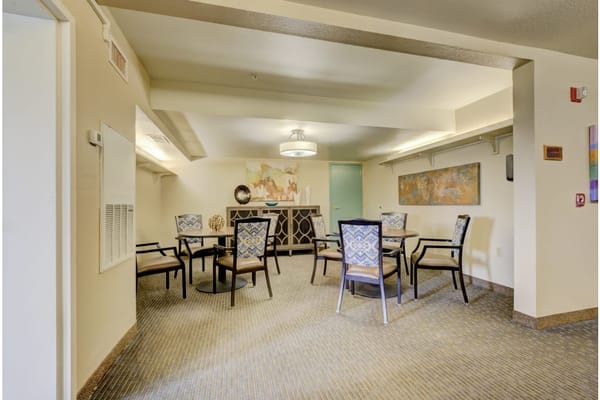 Cozy lounge area with tables and chairs in a senior living facility