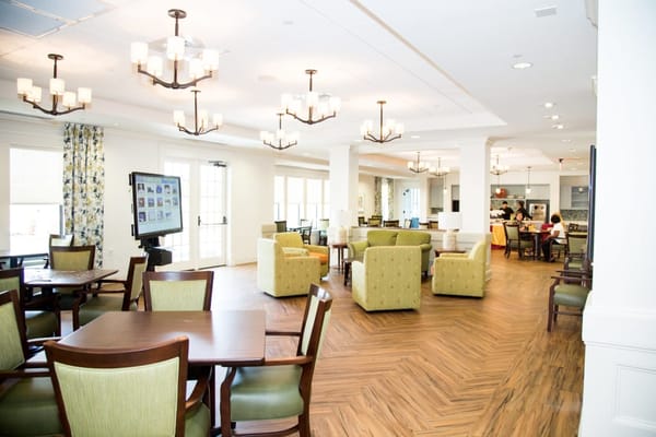 Bright and inviting common area with tables and chairs at The Glen at Lake Oconee Village.