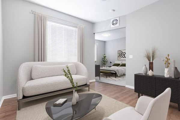 Stylish living room featuring a sofa and a view into an adjoining bedroom