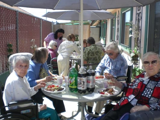 Residents enjoying a meal outdoors at a table