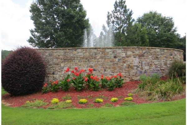 Entrance sign of Vernon Woods with fountain and flowers