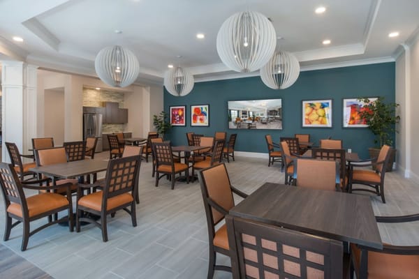 Brightly lit dining area with wooden tables and chairs