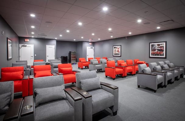 Cozy theater room with red and gray seating