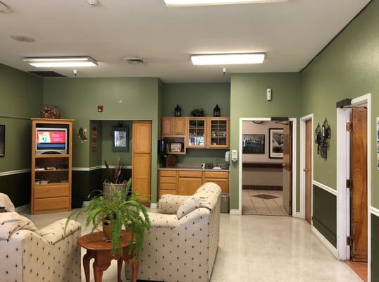 Common area with seating and kitchenette in a senior living facility