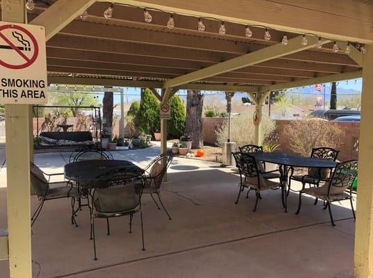 Covered outdoor seating area with tables and chairs